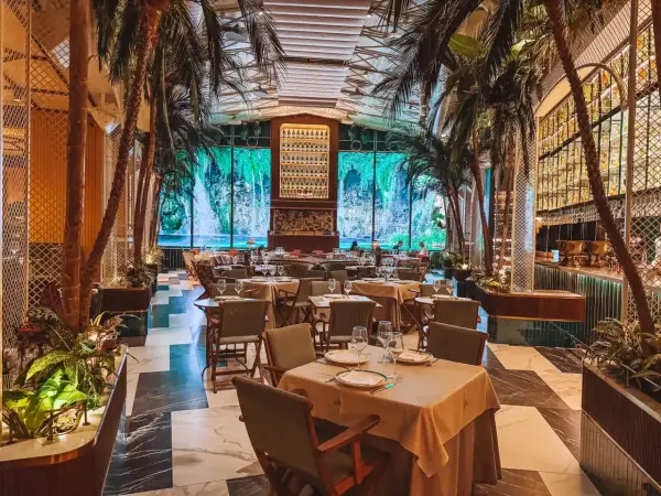 Tropische Atmosphäre in einem der Restaurants in Valencia. Palmen und ein Wasserfall-Bild im Hintergrund schaffen ein einzigartiges Ambiente.